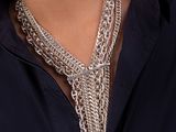 woman wearing a necklace and earrings with a chain around her neck