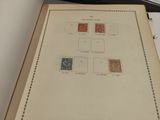 an open book with stamps on it sitting on a table