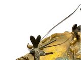 a gold clock with a dragonfly on it ' s face