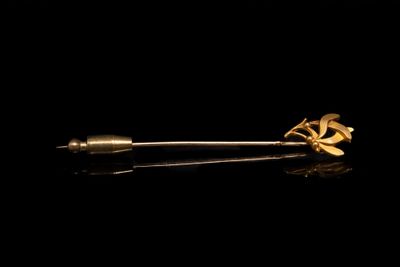 un gros plan d'une broche en or ornée d'une fleur