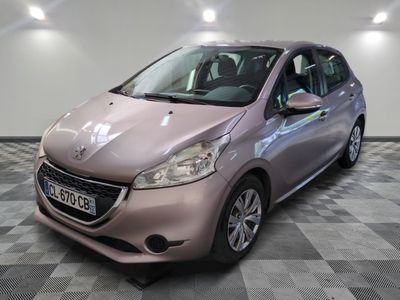 La petite voiture rose est garée dans la pièce au sol à carreaux.