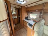 a view of the inside of a camper with a sink and a refrigerator