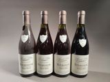 four bottles of wine are lined up on a table