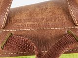 the inside of a brown and green handbag with a brown handle