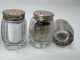 three salt and pepper shakers sitting next to each other on a table
