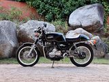 a black motorcycle parked in front of a large rock