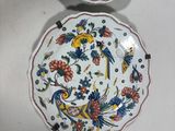 two plates with floral designs on them are sitting on a white surface