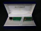 two green fountain pens in a blue box on a black surface