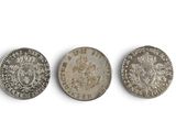 three silver coins, one of which has a crown and one of which has a crown on it