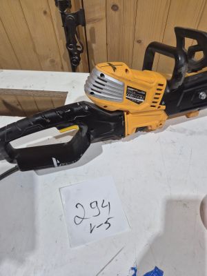 une tronçonneuse posée sur une table, à côté d'un panneau