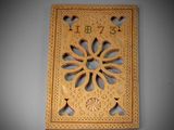 a wooden plaque with a flower design on it