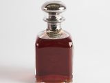 a small bottle of liquor sitting on a white surface