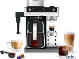a coffee maker with a cup of coffee next to it