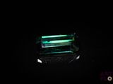 Une tourmaline vert émeraude brille dans l'obscurité