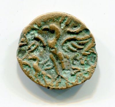 an old coin with a bird on it sitting on top of a white surface