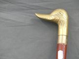 a gold and red walking stick with a bird head on it