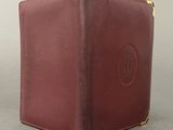 brown leather case with a round logo on the front