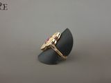 Gros plan sur une bague en or ornée d'une pierre rouge