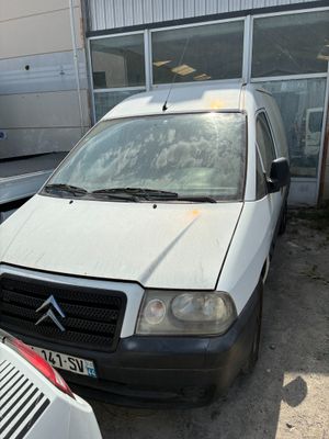une petite camionnette blanche garée devant un bâtiment