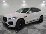 un SUV Jaguar blanc garé dans un showroom au sol carrelé