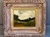 une peinture à l'huile d'un paysage avec des arbres dans un cadre doré