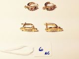 three pairs of earrings and a tag on a white surface