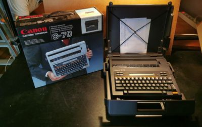 deux vieilles machines à écrire posées l'une à côté de l'autre sur une table
