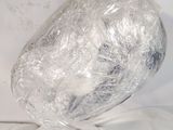 a large rock wrapped in plastic on top of a bed