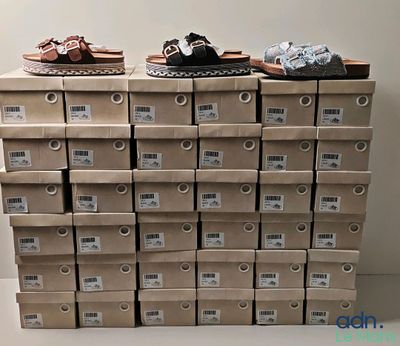 des boîtes de chaussures sont empilées sur une table