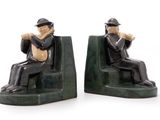 two figurines of a man sitting on a bench