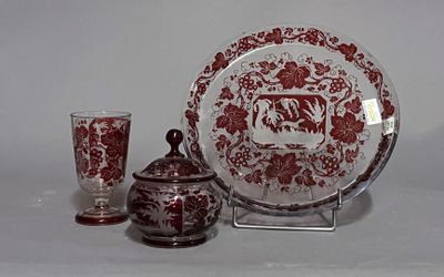 une assiette rouge et blanche et un verre posés sur une table