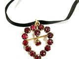 an image of a necklace with red stones on a black ribbon