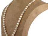 a close up of a mannequin with a pearl necklace on it