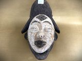 a wooden mask with a black hat on top of it