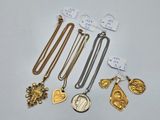 a collection of gold and silver necklaces and pendants