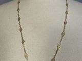 a close up of a mannequin torso wearing a gold necklace