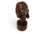 sculpture of a woman ' s head on a wooden base