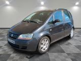 a picture of a small blue car parked in a garage