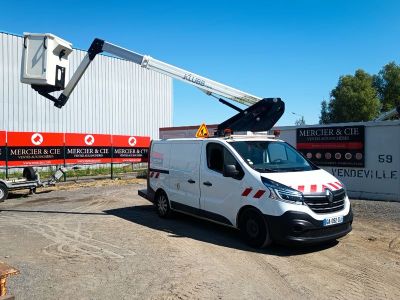 un camion blanc garé devant un bâtiment sur lequel est installée une grue