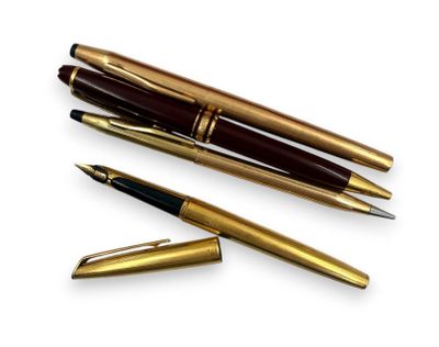 trois types de stylos différents sont alignés sur une surface blanche