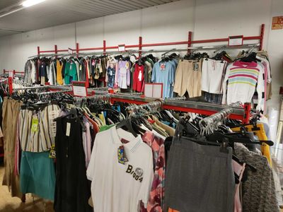 de nombreuses chemises suspendues à un portant dans un magasin