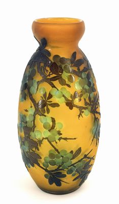 a yellow vase with green flowers on it on a white background