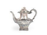 une théière ancienne en argent, ornée de motifs élaborés sur fond blanc