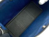 the inside of a blue purse with a black leather handle