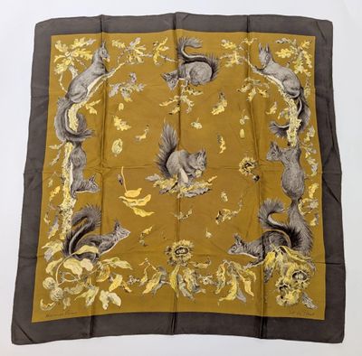 une écharpe carrée marron et jaune, ornée d'écureuils et de fleurs