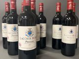 six bouteilles de vin rouge sont alignées sur une table