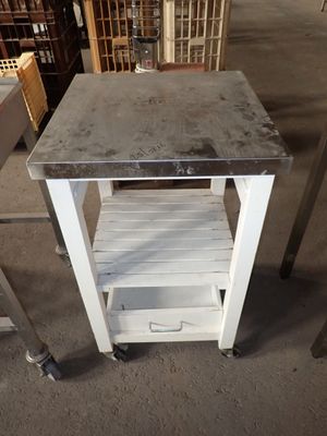 une table sur laquelle se trouve une étagère, au milieu d'une pièce