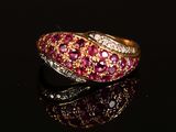 a close up of a ring with pink and white stones on a black surface
