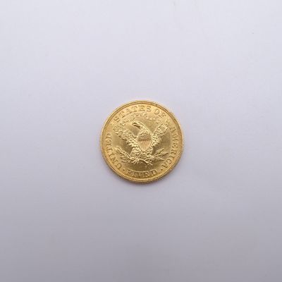 gros plan d'une pièce d'or sur une surface blanche