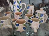 une vitrine sur laquelle sont disposées de nombreuses tasses et cruches